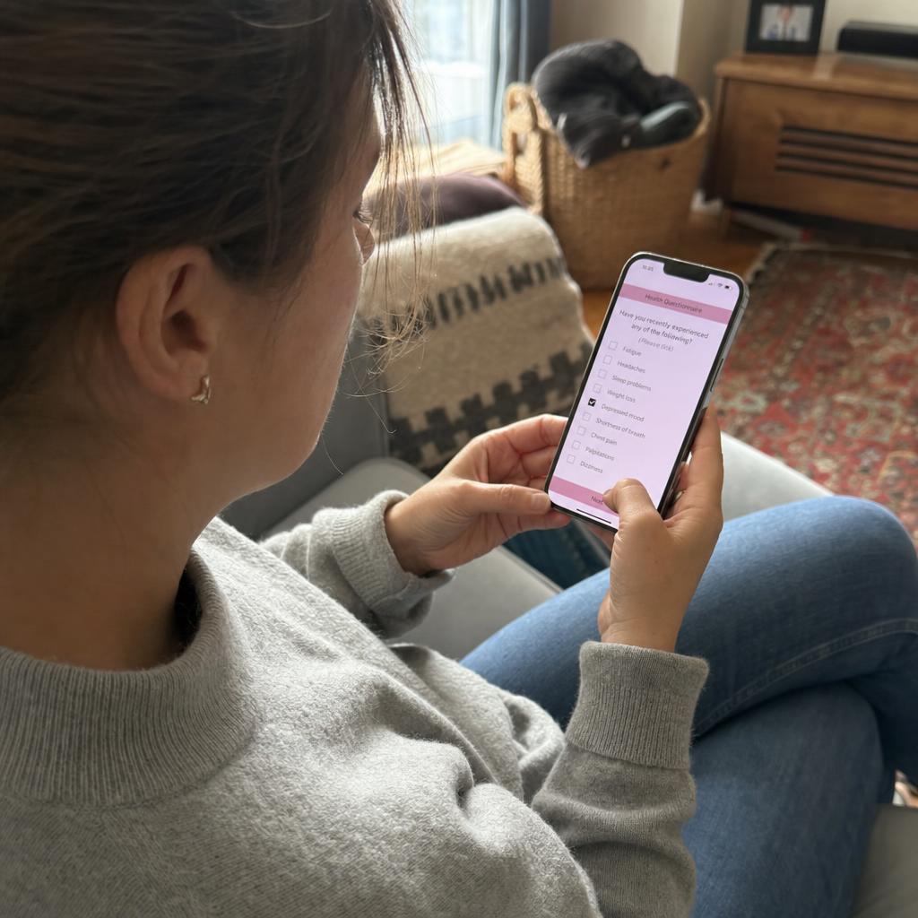 Person completing a health questionnaire on their phone at home
